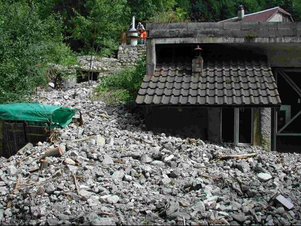 Dépôt de lave torrentielle et dégâts aux constructions.