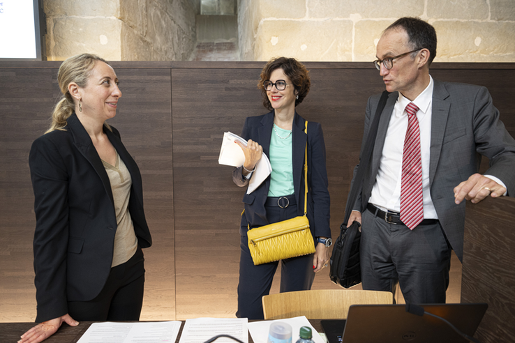 Les trois personnes discutent à l'issue de la conférence de presse.