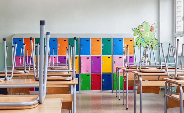 une salle de classe colorée, les chaises sont sur les tables