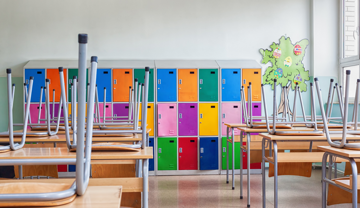 une salle de classe colorée, les chaises sont sur les tables