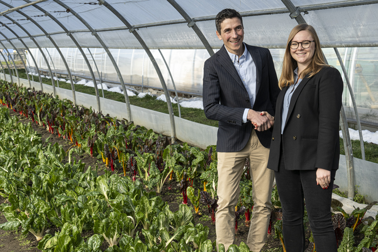 Les deux personnages posent debout, devant une serre de l'école d'agriculture Agrilogie à Marcelin (Morges). A leurs pieds, des plants d'épinards.