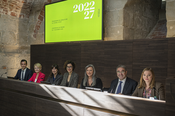 Les sept membres du gouvernement assis à leurs pupitres dans la salle des médias du château cantonal.