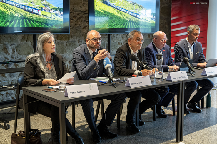 Les membres lors de la conférence de presse, assis derrière une table.