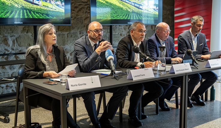 Les membres lors de la conférence de presse, assis derrière une table.