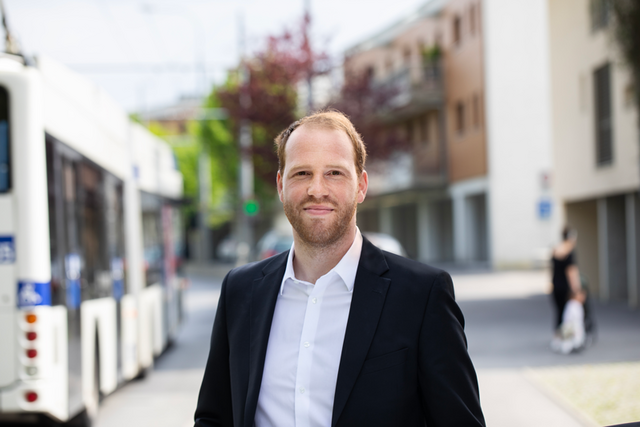 Le futur préfet pose dans la rue, on voit un bus derrière lui.