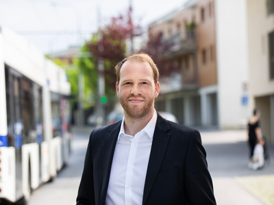 Le futur préfet pose dans la rue, on voit un bus derrière lui.