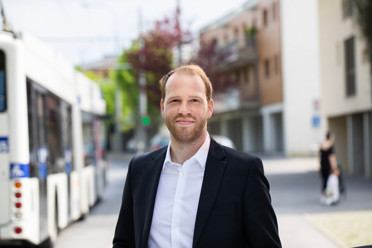 Le futur préfet pose dans la rue, on voit un bus derrière lui.