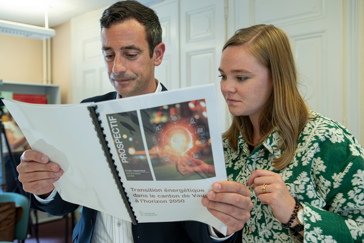 Les deux personnages debout, en train de parcourir l'étude en question.