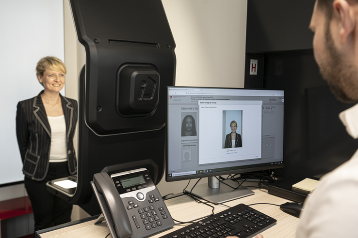 Les nouvelles installations ont été inaugurés le 21 mars par la conseillère d'Etat Isabelle Moret. La conseillère d'Etat pause dans l'une des cabines qui sert aux photos d'identité.