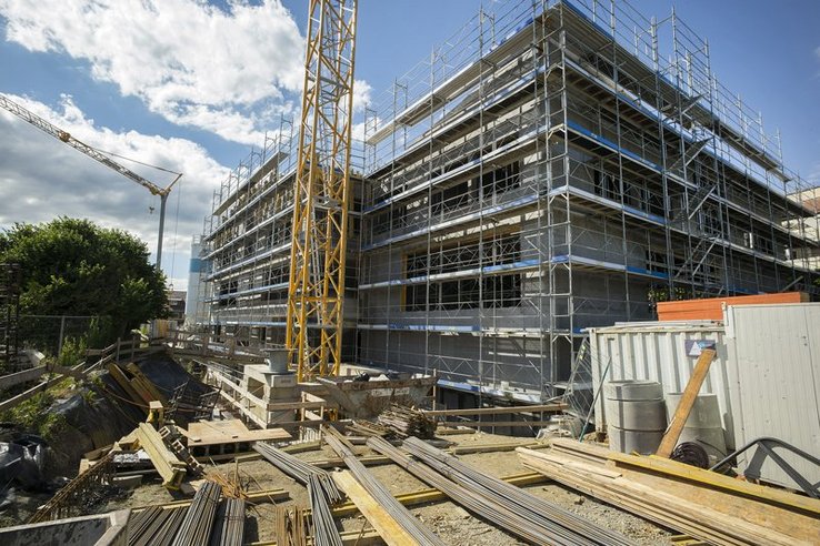 Le bâtiment en chantier, caché par des échafaudages. On voit le pied d'une grue.