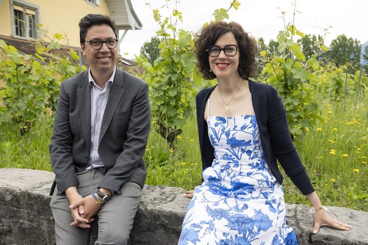Les deux personnes posent assises sur un mur de vigne.