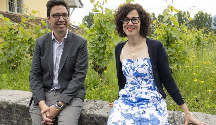 Les deux personnes posent assises sur un mur de vigne.