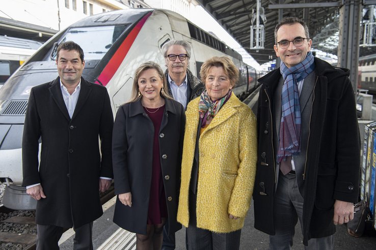 Les personnages posent devant la locomotive d'un tégévé en gare de Lausanne.