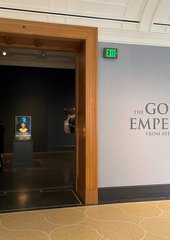 Le buste apparaît dans l'encadrement de porte de la salle de la Getty Villa. Sur un grand panneau dans le couloir posé à coté de la porte, on lit: "The gold emperor from Aventicum".
