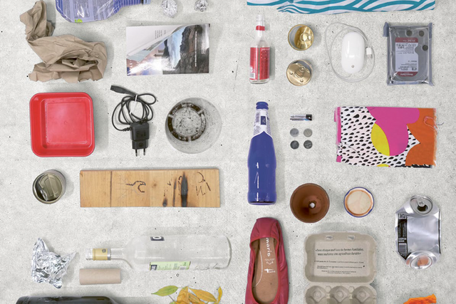 divers déchets trouvés dans des poublles, nettoyés et alignés (ballerine de femme, bouteilles, emballages, etc.)