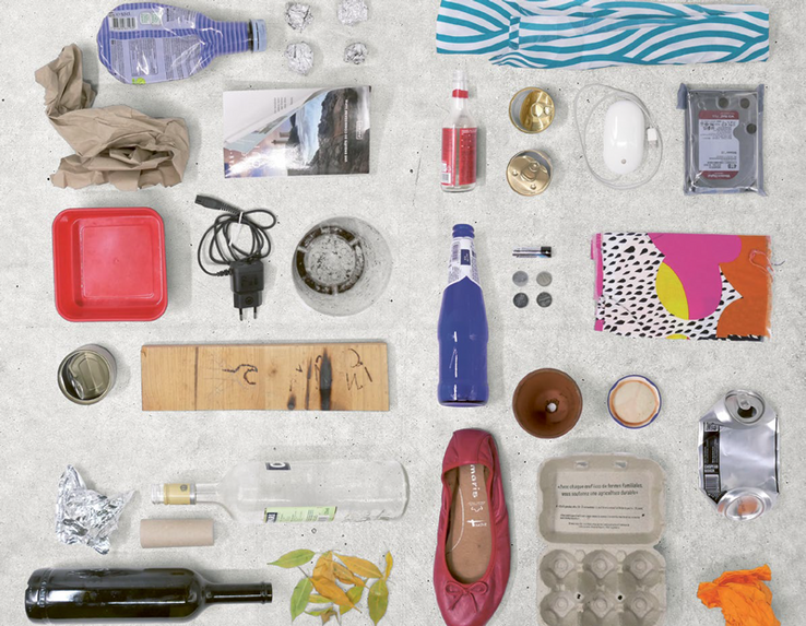 divers déchets trouvés dans des poublles, nettoyés et alignés (ballerine de femme, bouteilles, emballages, etc.)