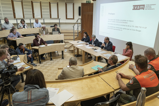 En conférence de presse, les membres du Conseil d'Etat sont insallés dans un petit amphithéâtre en présence de journalistes et de membres de la Protection civile.