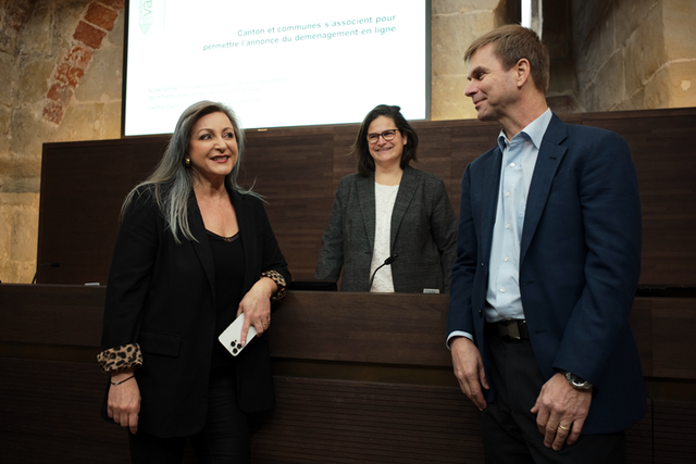 Les trois personnes en conférence de presse, devant un écran où l'on lit "Canton et communes s'associent pour permettre l'annonce de déménagement en ligne".