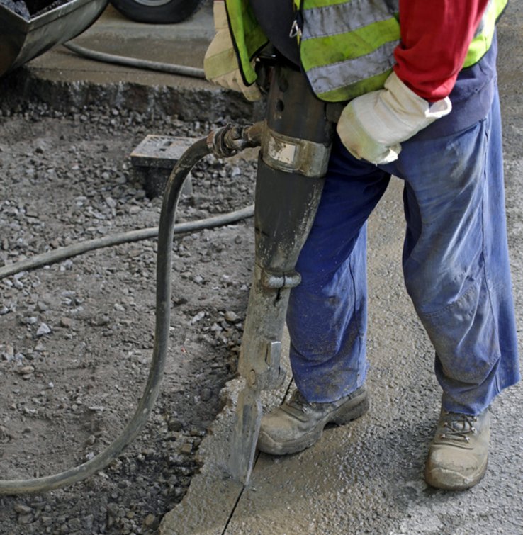 jambes d'un ouvrier travaillant au marteau piqueur