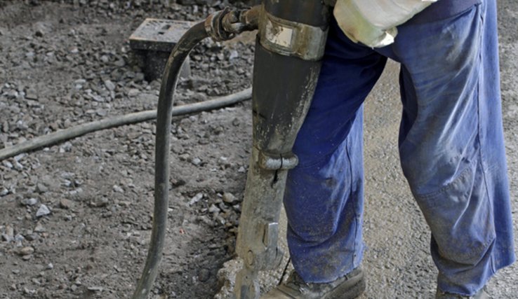 jambes d'un ouvrier travaillant au marteau piqueur