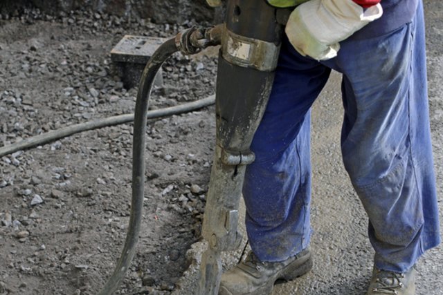jambes d'un ouvrier travaillant au marteau piqueur