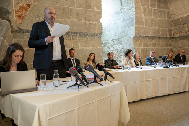 l'expert est debout avec des feuilles en main. Au fond, le Conseil d'Etat, assis.