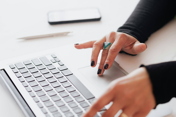 Image illustrative d'une femme écrivant au clavier d'un ordinateur