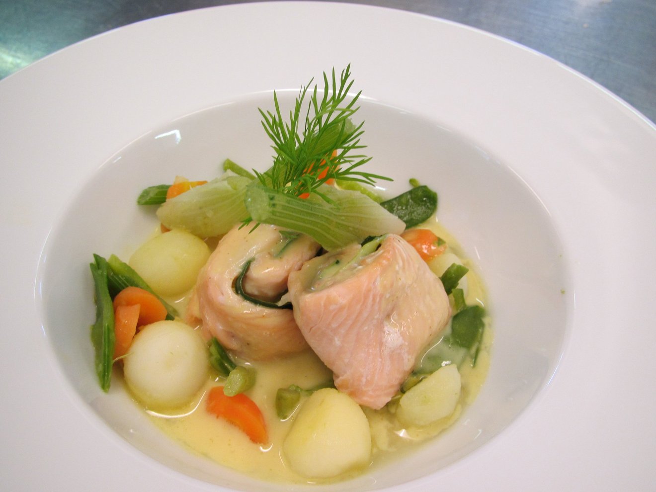 Présentation du plat, roulade de poisson au milieu, entouré de petits légumes