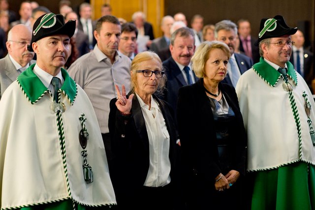A gauche, Anne Weill-Levy lève une main aux côté d'Eliane Rey. Elles sont entourées de deux huissiers en uniforme.