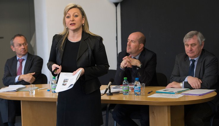 La conseillère d'Etat parle, debout. Derrière elle, assis à la table, Messieurs Olivier Français (Ville de Lausanne), Pierre-Yves Gruaz et Vincent Krayenbühl (Direction générale de la mobilité et des routes).