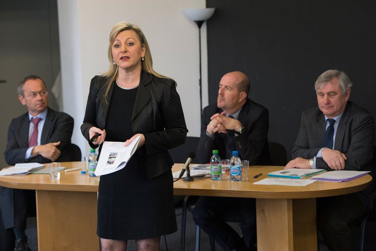 La conseillère d'Etat parle, debout. Derrière elle, assis à la table, Messieurs Olivier Français (Ville de Lausanne), Pierre-Yves Gruaz et Vincent Krayenbühl (Direction générale de la mobilité et des routes).