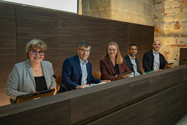 les personnes posent dans la salle de conférences de presse du château cantonal.