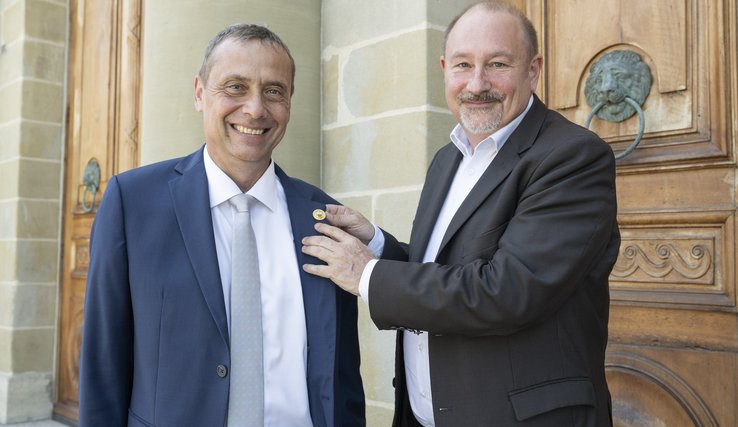 Le président sortant, Stéphane Montangero, et entrant, Patrick Simonin, se transmettent le pin's présidentiel Le président sortant et entrant se passent le pin's présidentiel