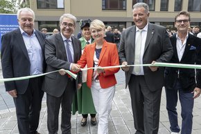 Les personnes sont derrière le ruban, que tient madame Moret tandis que monsieur Borloz le coupe.