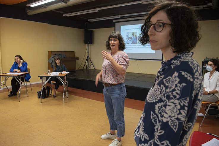 Les deux personnes debout parlent. Au fond, les conseillères d'Etat Rebecca Ruiz et Cesla Amarelle sont assises.