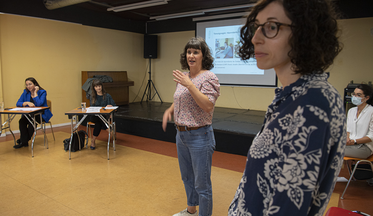 Les deux personnes debout parlent. Au fond, les conseillères d'Etat Rebecca Ruiz et Cesla Amarelle sont assises.