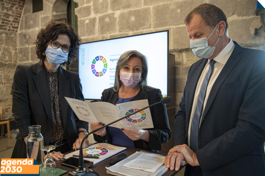 Les trois personnages avant la conférence de presse, devant un écran