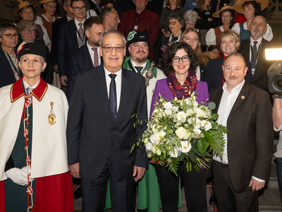 Les persones posent au Palais fédéral. Une huissière de la Confédération se tient à gauche à côté de M. Parmelin, au centre madame Luisier Brodard tient un bouquet de fleurs. Tout à droite, monsieur Montangero.