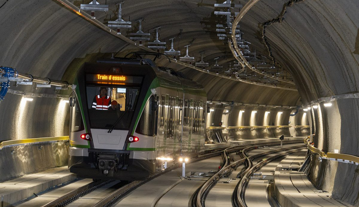 Vue d'un train d'essais roulant dans le nouveau tunnel, très éclairé.