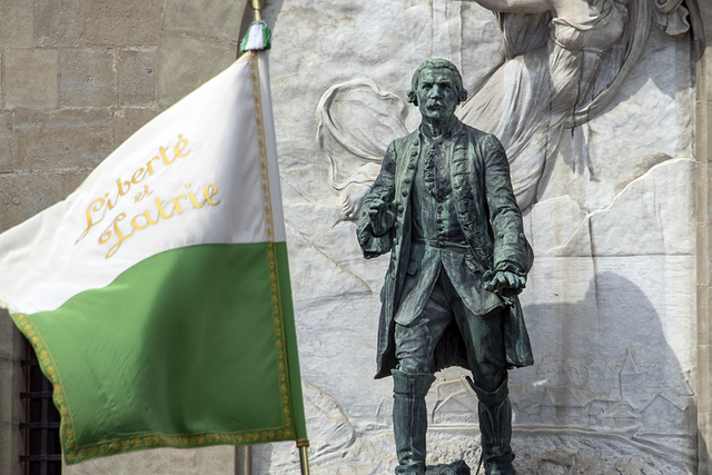 La statue du Major Davel devant le château Saint-Maire à Lausanne. Au premier plan, un ancien drapeau vaudois flotte avec la devise liberté et patrie.