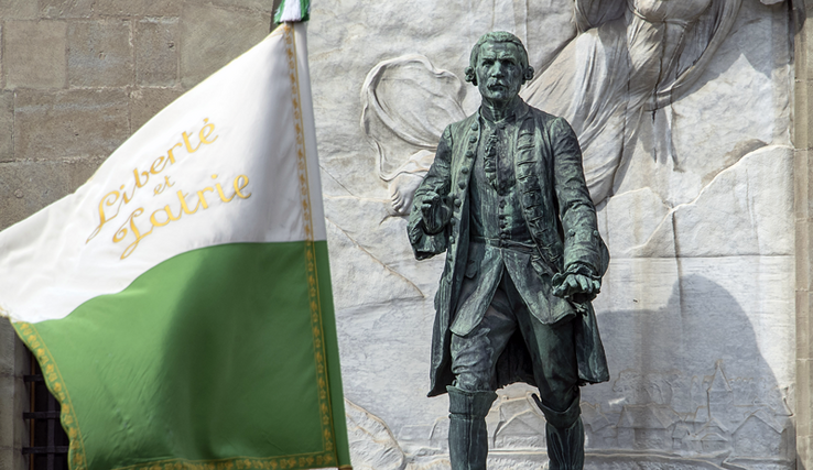 La statue du Major Davel devant le château Saint-Maire à Lausanne. Au premier plan, un ancien drapeau vaudois flotte avec la devise liberté et patrie.