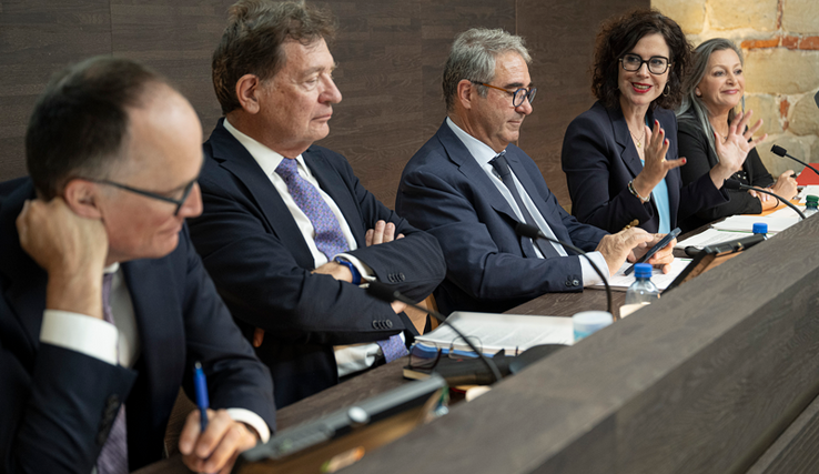 Les personnages assis à leur pupitre durant la conférence de presse.