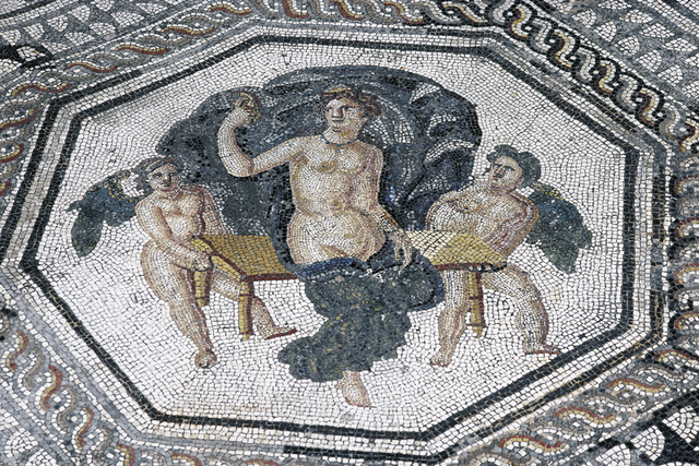 La déesse Vénus représentée assise sur un banc, nue à l'exception d'un tissu qui cache ses jambes. Entourée de deux personnages. Le tout s'inscrit dans une forme octogonale.