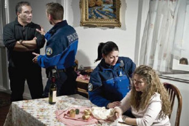 deux policiers avec un couple dans une salle à manger d'appartement