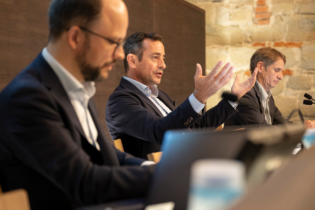 Les trois personnes assises au pupitre de la salle des conférences de presse au chateau cantonal.