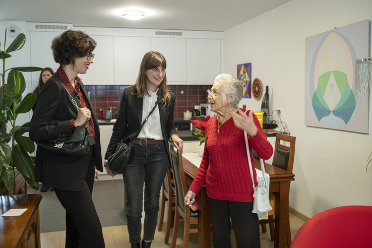 Les deux conseillères d'Etat discutent avec la locataire de l'appartement, debout, dans la salle à manger. 