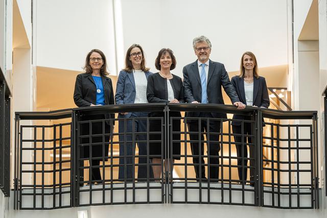 Les personnes posent à un balcon du Palais de justice de l'Hermitage.