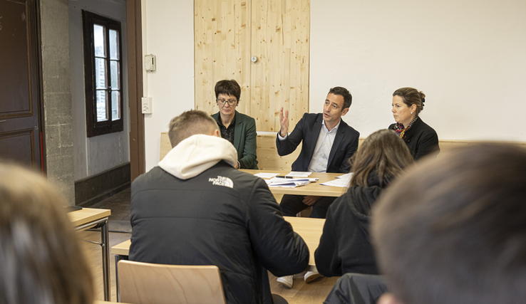 Les personnages assis en conférence de presse.