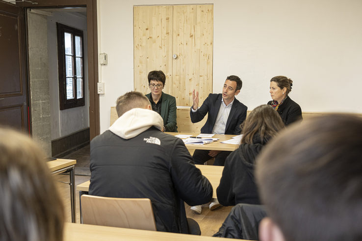 Les personnages assis en conférence de presse.