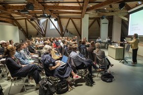 les personnes réunies, assises, écoutent le mot de bienvenue de la conseillère d'Etat Nuria Gorrite, au pupitre.